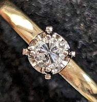 Top-down close-up of round diamond in six-prong head.