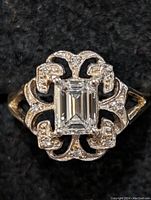 Top-down view showing emerald-cut center diamond and surrounding filigree pave setting