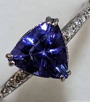 Extreme close-up of the trillion-cut tanzanite and diamond-accented band
