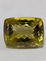 Front view of the cushion cut lemon quartz gemstone showing its transparency and faceted pattern.