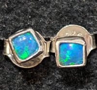 Close-up of the two silver earrings showing the blue-green iridescent square opalite stones set in silver.