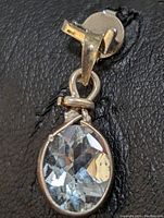 Close-up front and side view of the sterling silver aquamarine pendant showing the faceted aquamarine in a bezel setting and the detailed bail.