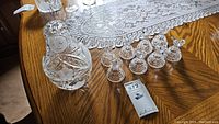 Photo showing the crystal nesting doll and 8 bird figurines on wooden table with lace doily.