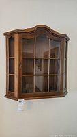 Front view of wood wall mounted display case showing glass pane design and overall condition.