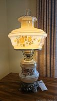 Full view of vintage lamp showing top and bottom glass floral shades and metal base.