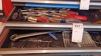 Top view of open drawer showing multiple screwdrivers, Allen wrenches, and drill bit set in plastic holder