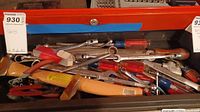 Tool drawer filled with various hand tools such as screwdrivers, socket wrenches, hammer, and cutters.