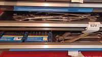 Drawer containing a blue plastic case with drill bits and several chrome wrenches.