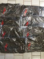 8 folded khaki windbreaker jackets packed in clear plastic, showing the Cardinal logo and red cardinal bird graphic on the front.