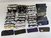 Overview of 20 eyeglasses and optical frames with 7 carrying cases, showing variety of frame styles and colors.
