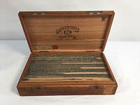 Wooden box with lid open showing organized Caslon lead type pieces inside.