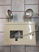 Top view of the emergency exit light showing dual round adjustable spotlights and front cutout window.