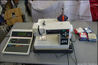 Overall view of embroidery machine, controller keypad and stack of floppy disks