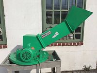 Front view of green-painted glass crusher with hopper and round crusher housing on metal tray