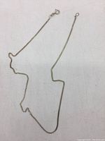 Full length view of the silver chain laid out showing chain link pattern.