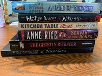Stack of six books showing titles on spine: A Tale of Time City, The Heroin Diaries, Kitchen Table Tarot, Servant of the Bones, The Ghostly Register, This Is Gonna Hurt.