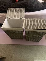 Two woven rectangular laundry baskets side by side with cloth liners inside and lids open and closed.