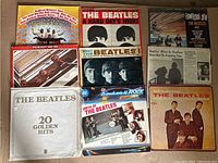 Eight Beatles LP album covers laid out on the floor