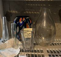 All six vases grouped on a shelf, showing shapes, colors, and the note about Swedish origin and signature.