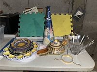 Overview of all items including Orrefor crystal vase, Italian pottery, plates, and decorative items on table