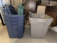 Five plastic storage bins nested together with lids on top, positioned next to a beige storage bin without lid, showing size and color variety.