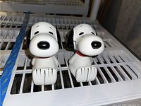 Front view of both ceramic Snoopy bookends placed side by side
