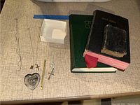 Wide shot showing the collection of jewelry, religious books, and accessories on a textured table