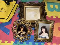 Three vintage wood framed wall art pieces showing detailed portraits of women and ornate carvings on frames.