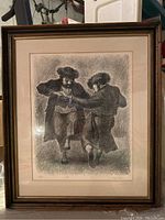 Full view of the framed wall art print showing two men dancing in traditional clothing.