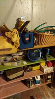 Photo of basement shelf with Ryobi cordless drill in blue carrying case, basket, and other household items.