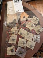 Top-view of table with loose black opal cabochons scattered and several packaged with handwritten weight labels.