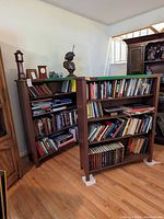 Two walnut 4-tier bookcases filled with books and some decorative items on top, showing front and side views.
