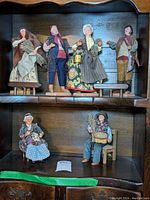 Full set of six Claude Carbonel figurines displayed on wooden shelf with two levels
