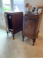 Two antique wooden cabinets standing side by side, showing front and side view