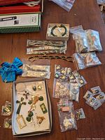 Overview of lot showing multiple pieces of jade and tiger's eye jewelry, including necklaces, pendants, rings, and pearl brooches arranged on table with packaging bags.
