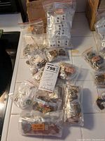 Full lot of Tiger's Eye jewelry in multiple clear plastic bags laid out on a surface including labeled bags and various small items.