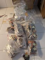 Multiple small plastic bags containing individually bagged Tiger's Eye stone jewelry including necklaces and pendants.