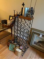 Photo showing metal wine rack with wooden top along with multiple wine and bar accessories placed on and around it.