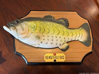 Close-up photo showing side view of the Big Mouth Billy Bass on a plaque with detailed scales and label.