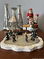 Village hockey scene figurine close up with scoreboards showing 'Tom 2 John 1'.