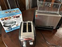 Overview photo showing GT Express 101 in box, Black & Decker wide slot toaster, and Rocco ReadyGrill unit on table.