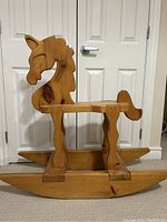 Right side view of vintage oak wooden rocking horse showing carved mane and minor chips.