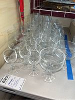 Group of 25 clear Bohemian crystal stemware glasses, placed on a table showing variety in sizes and styles.