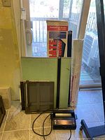 Full lot including Logan 401 mat cutter, mat boards, box, and Cordless WRAPid-seal II shrink wrapper on floor by door