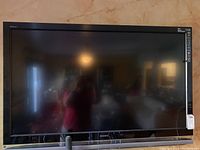Front view of Sony TV mounted on wall, showing the full screen and surrounding bezel.