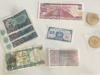 Mixed currencies including Mexican 20 Pesos note, South Korean 10 Won note, Thai 1 Baht note, Indonesian 500 Rupiah note, partial Chinese 5 Jiao notes and three commemorative coins
