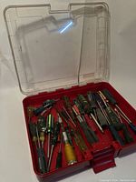 Open case showing multiple assorted screwdrivers with different handle colors and sizes inside.