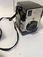 Side angled view showing the camera body, strap and lens area.