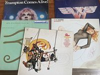 Photo showing five vinyl LP albums with notable rock bands: Frampton Comes Alive!, Chicago Greatest Hits, Van Halen, The Cars Candy-O, and The Alan Parsons Project Eye in the Sky.