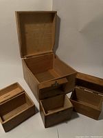 Open large wooden box showing interior and box joint corners. Two smaller wooden boxes beside it with open lids.